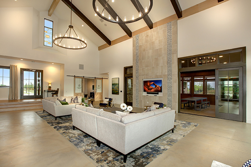 A large living room with a large white couch and a large television.