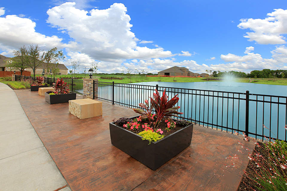 A deck with a flower pot and a body of water in the background.