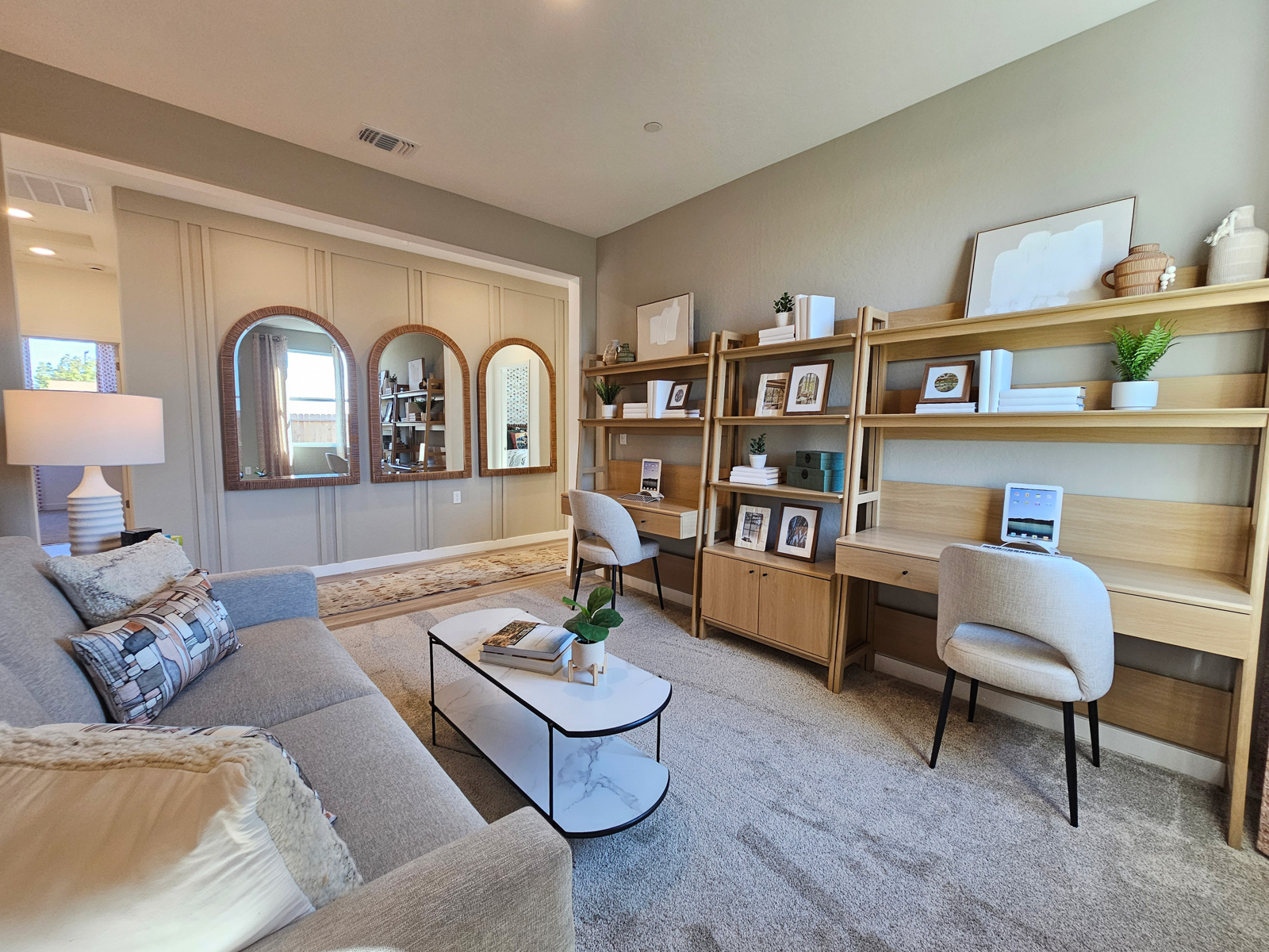 A living room with a desk and a couch.