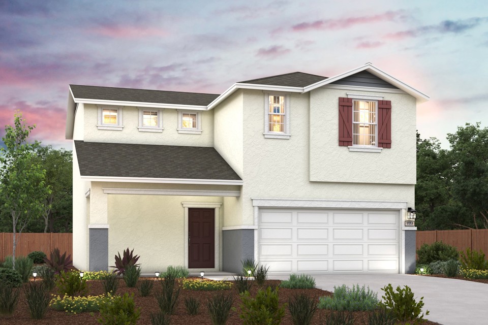 A house with a garage and bushes in front of it.