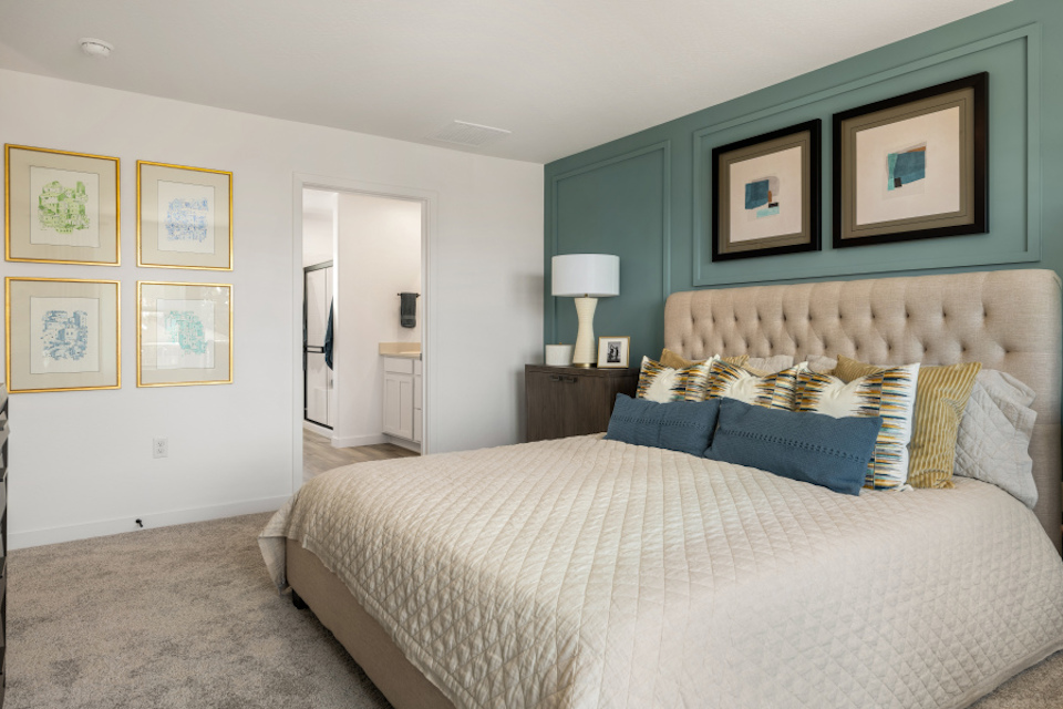 A bedroom with a bed and a lamp.
