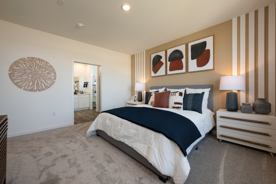 A bedroom with a bed and lamps.