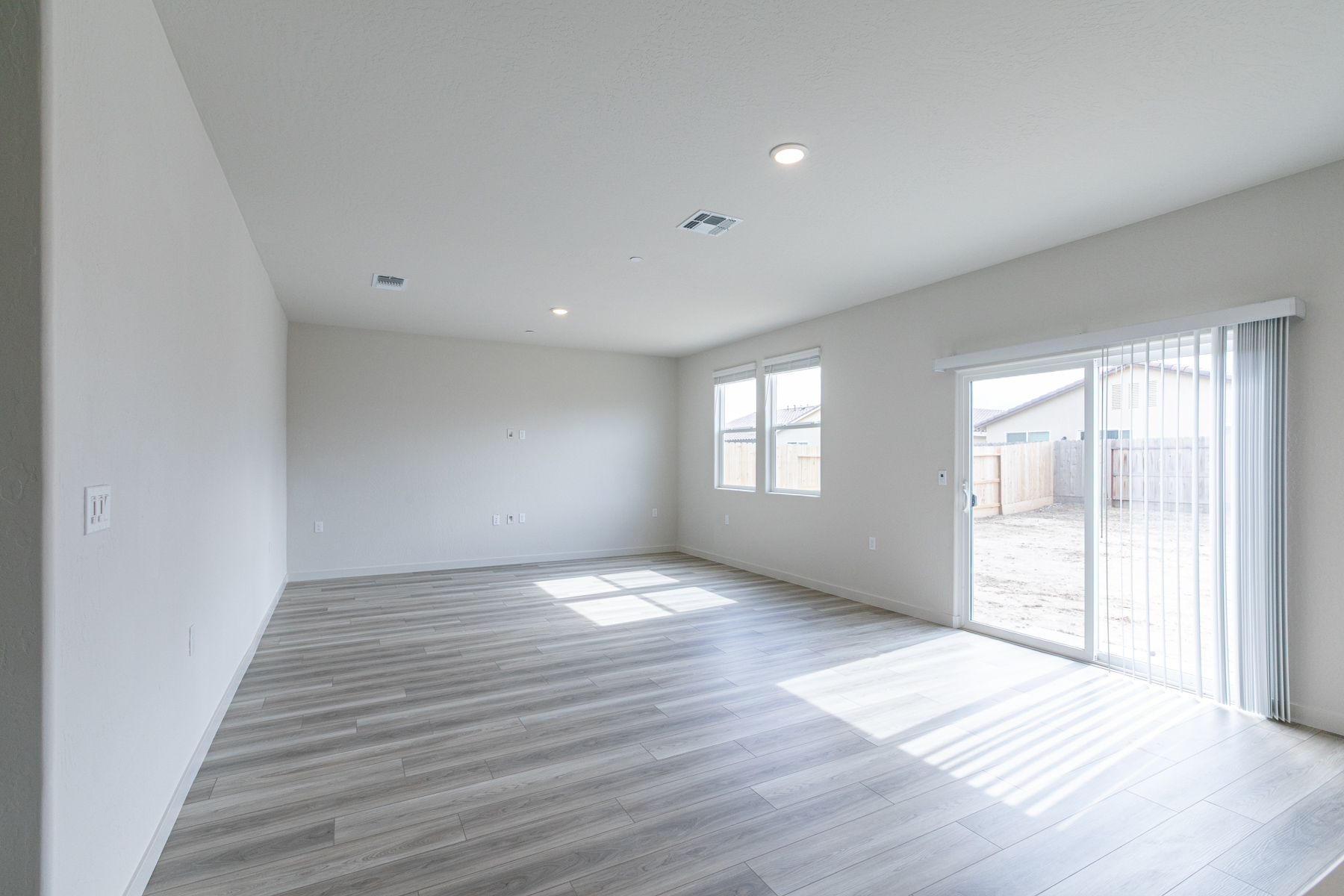 A room with a wood floor and glass doors.