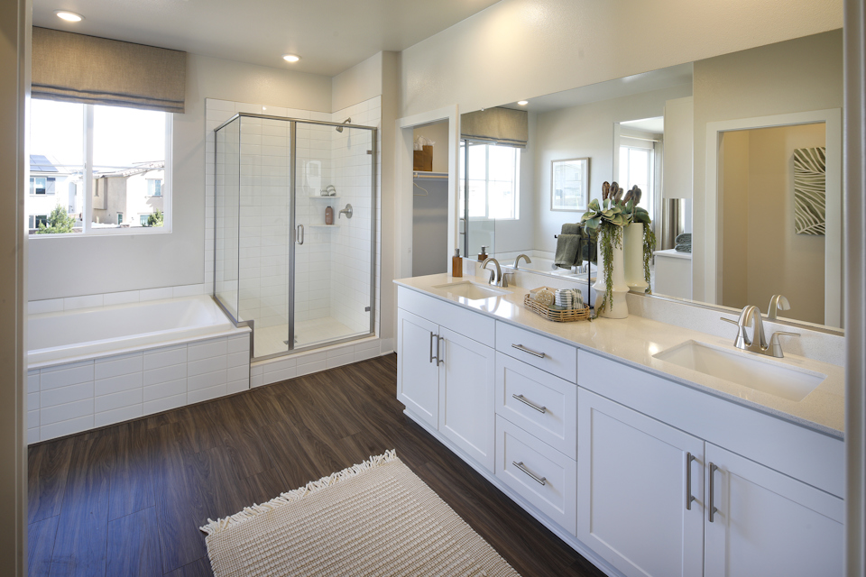 A bathroom with a tub sink and a mirror.