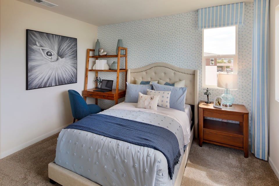 A bedroom with a bed and a desk.