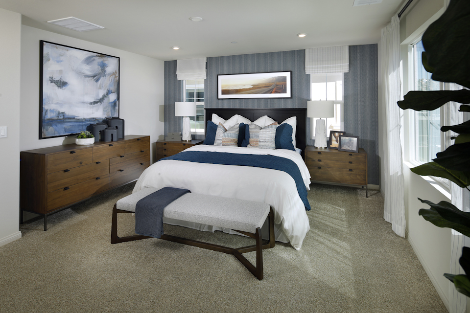 A bedroom with a bed and a bench.