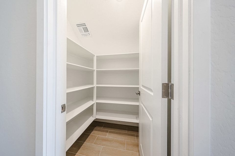A white closet with white doors.