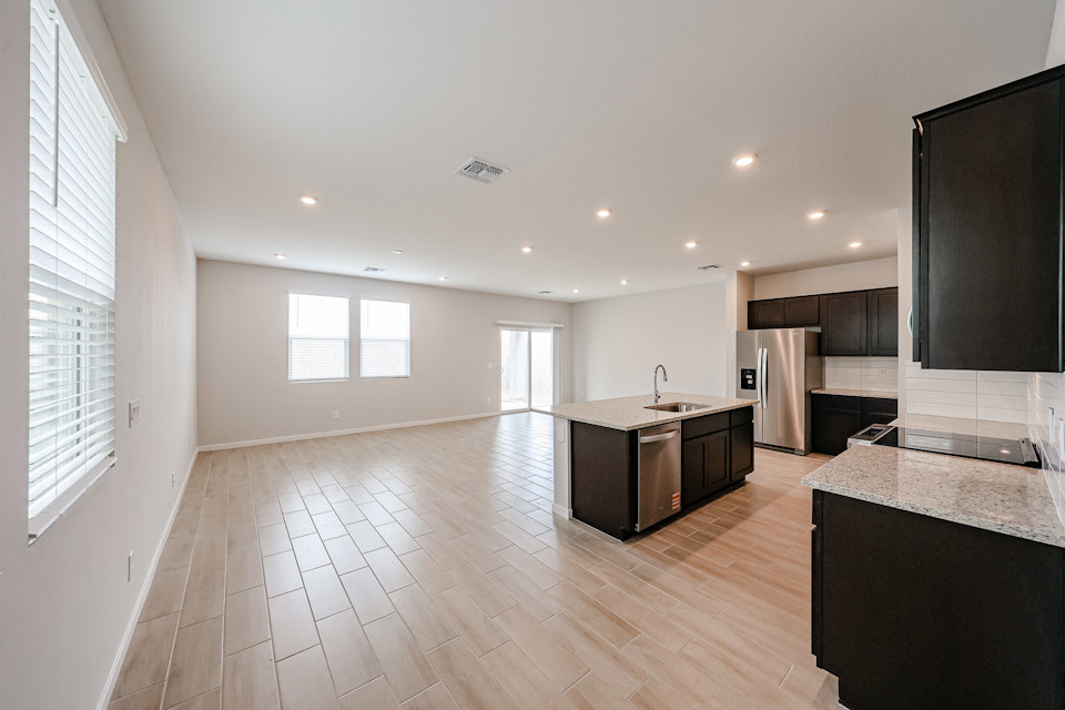 A large kitchen with a wood floor.