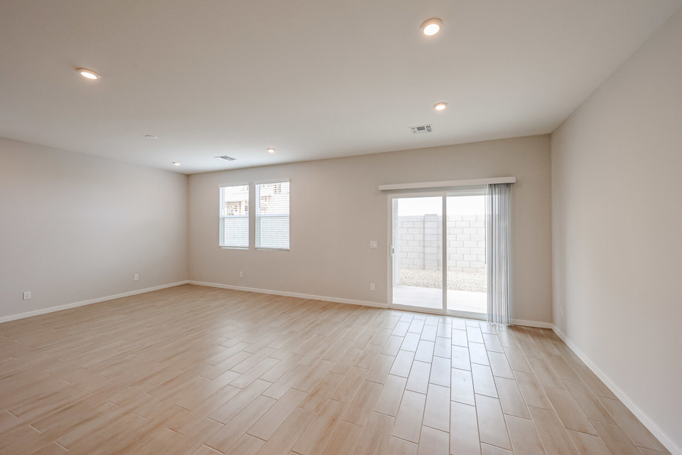 A room with a wood floor and a wood floor with a white door.