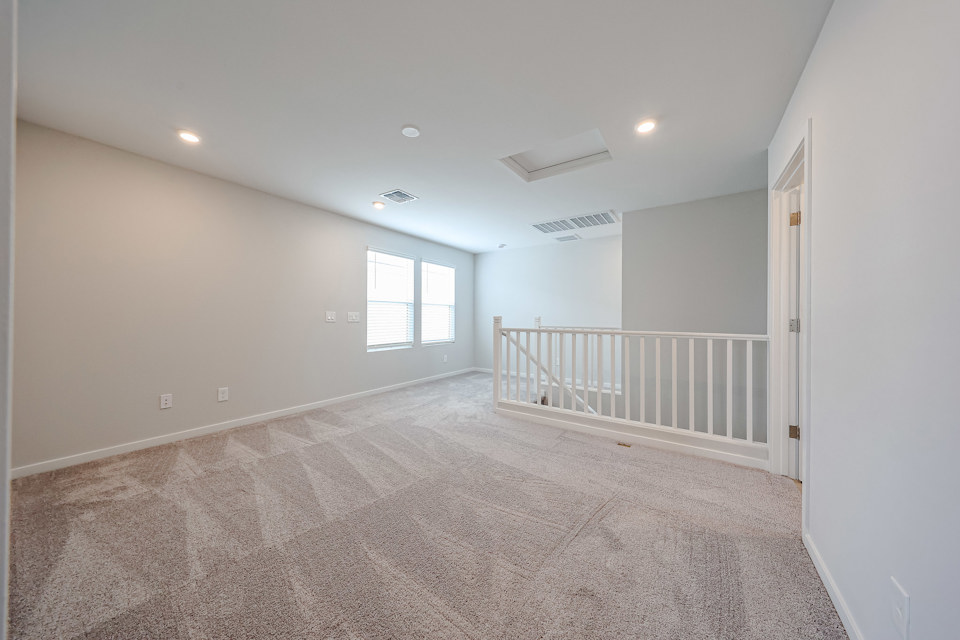 A room with a carpet and a railing.