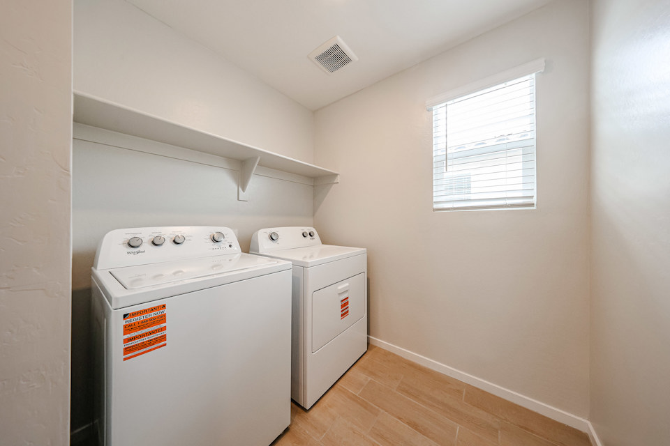 A room with a washing machine and a dryer.