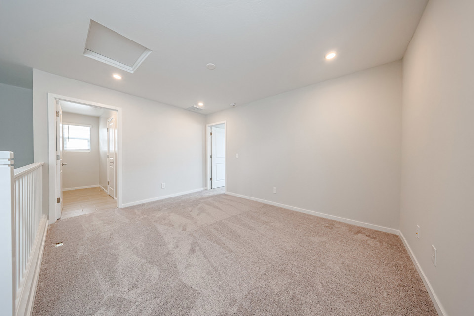 A room with a carpet and a white wall.