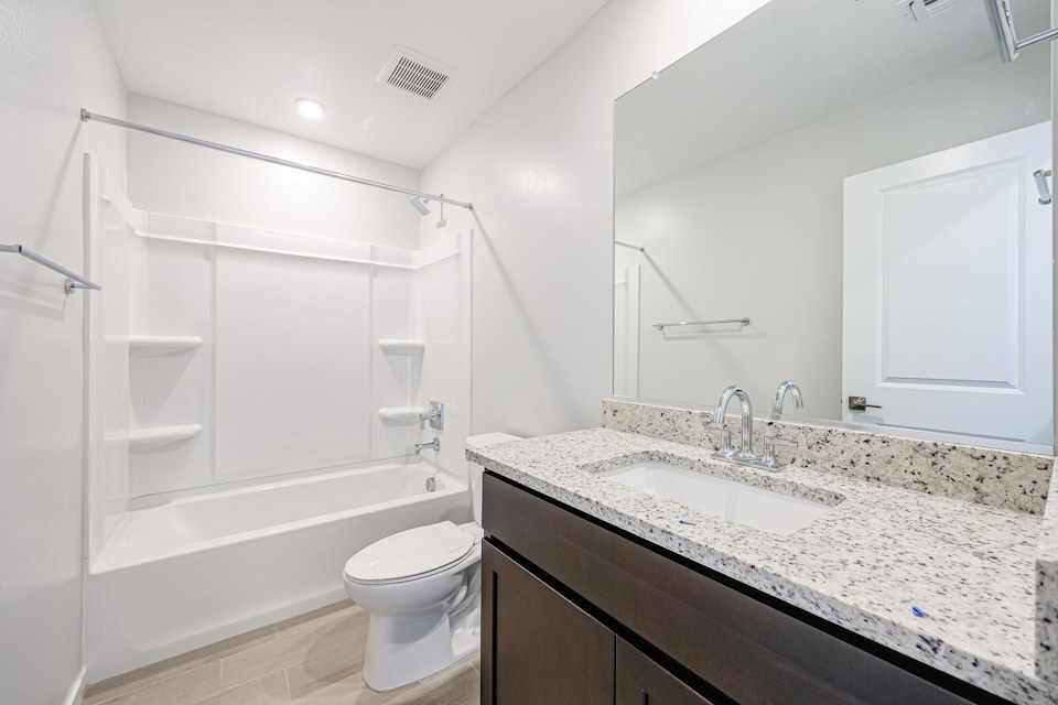 A bathroom with a tub sink and toilet.