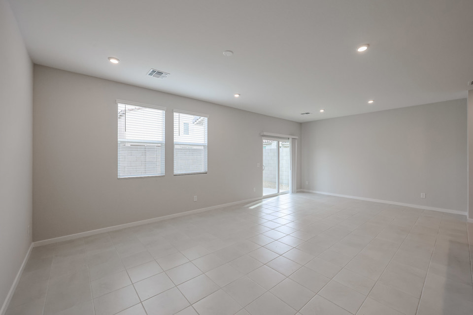 A room with white tile floor and windows.