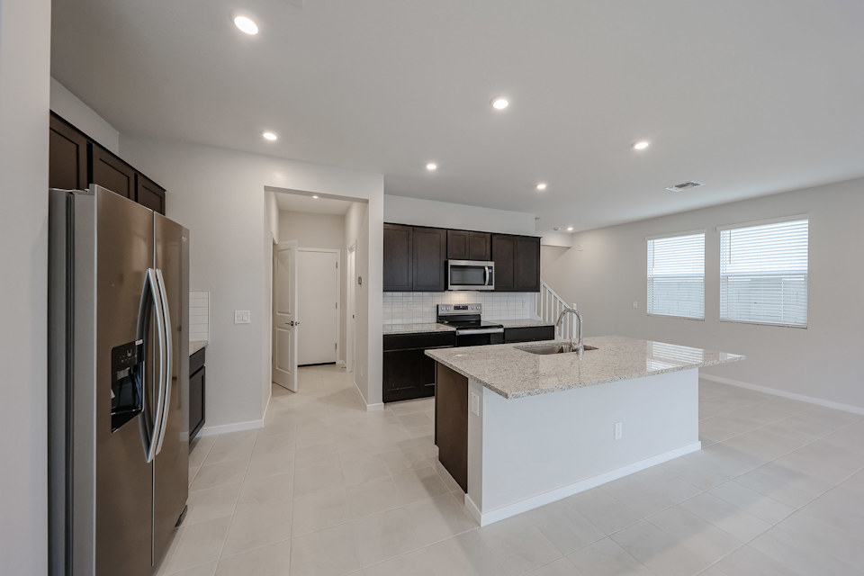 A kitchen with a marble counter top.