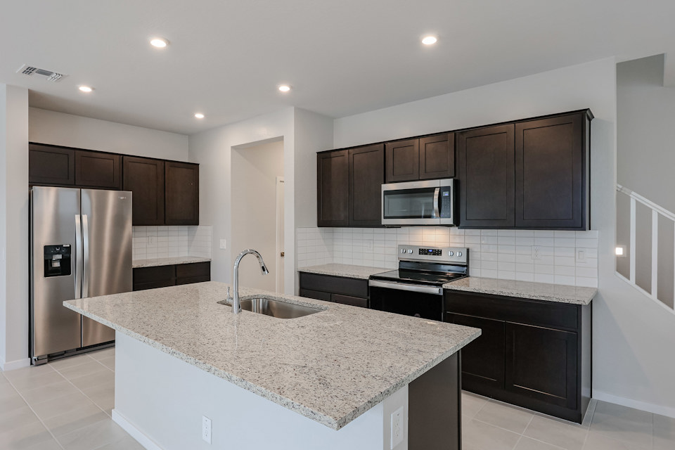 A kitchen with black cabinets.