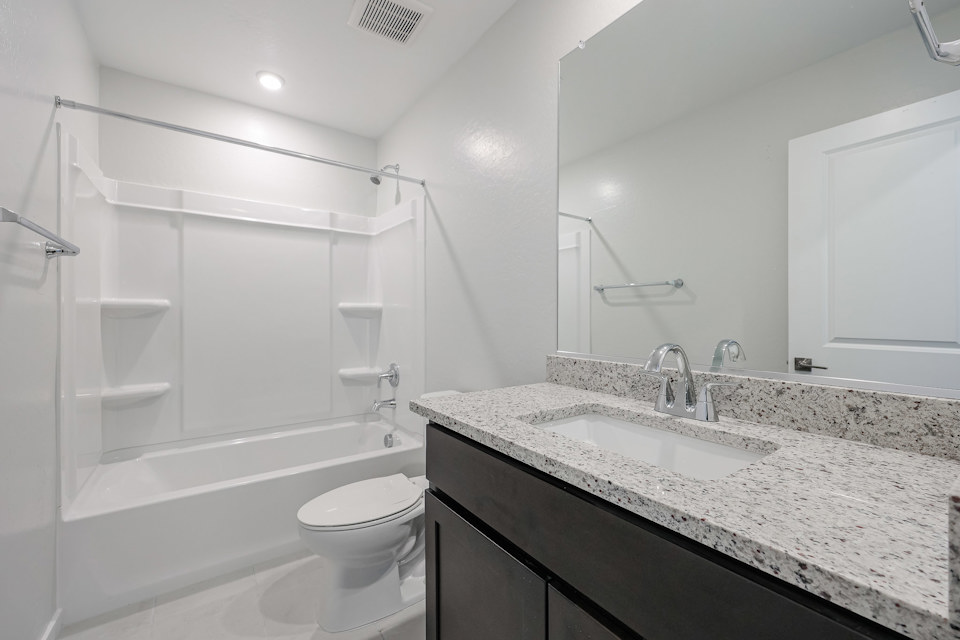 A bathroom with a marble countertop.