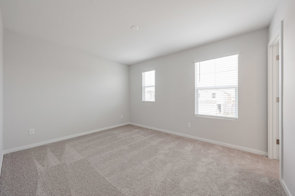 A room with a carpet and windows.