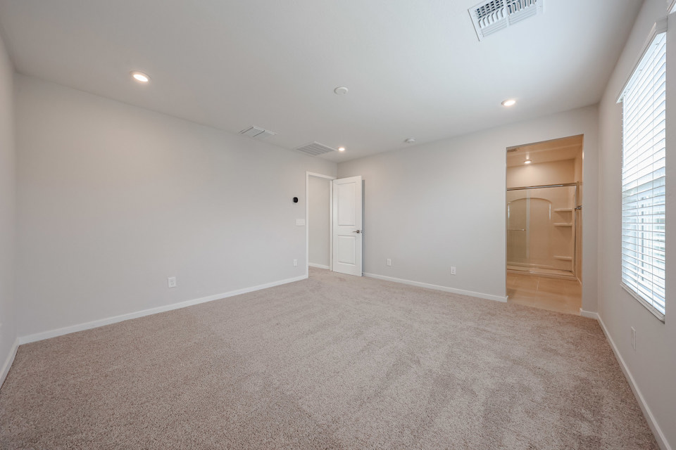 A room with a carpet and a door.