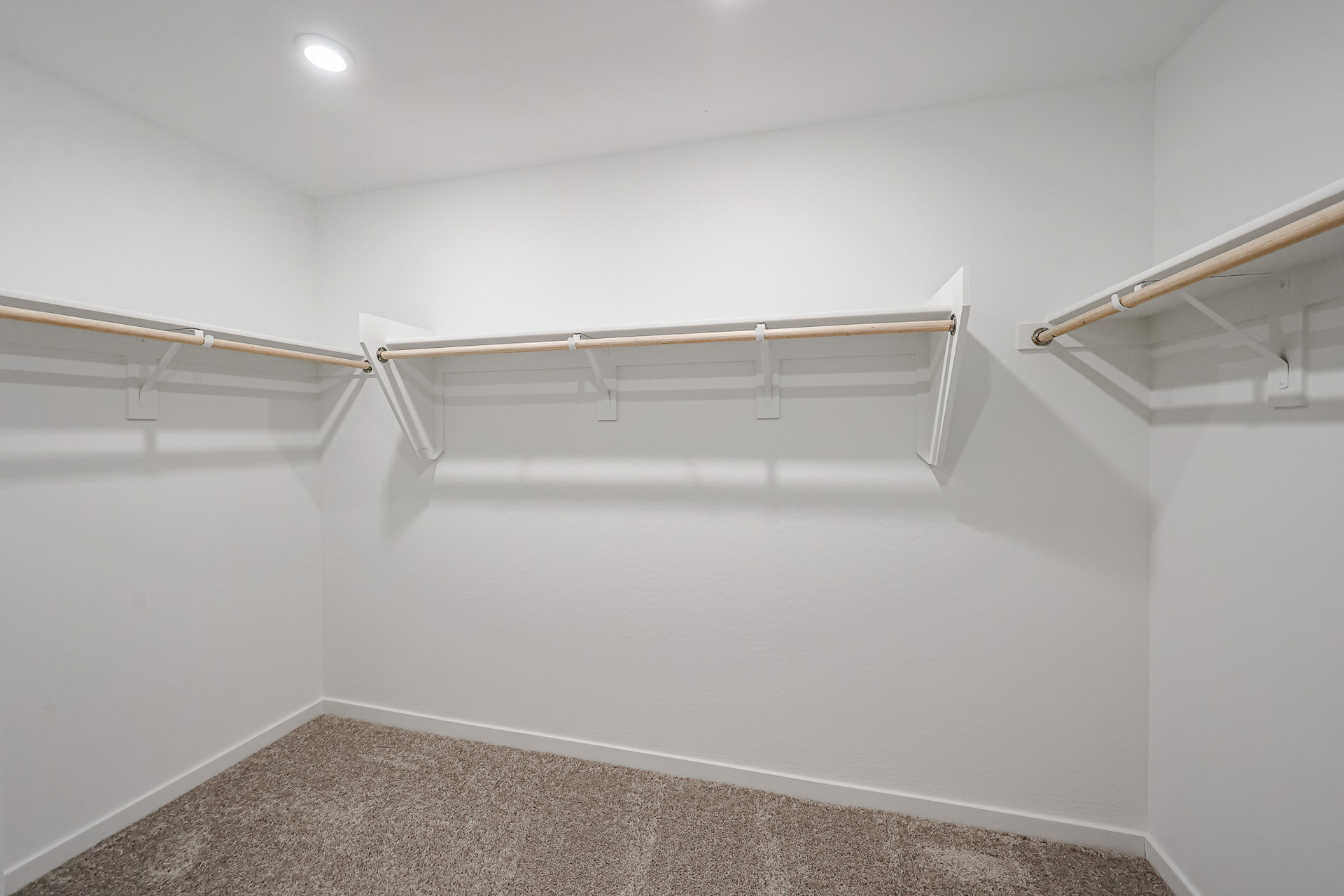 A white wall with a metal bar.