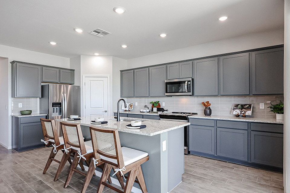 A kitchen with a table and chairs.