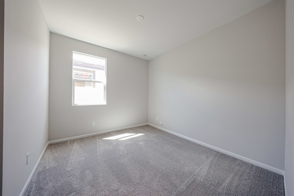 A room with a carpet and a window.