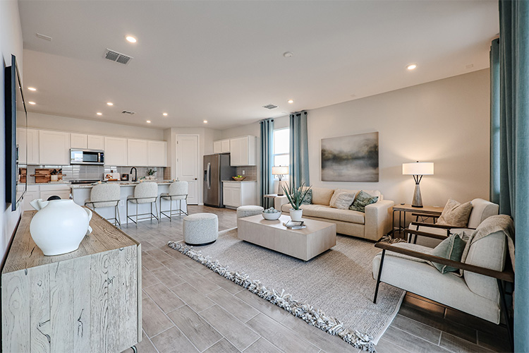 A large living room with a large rug and a large window.