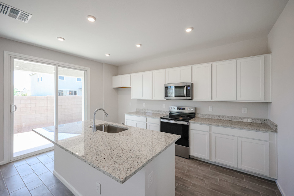 A kitchen with white cabinets.