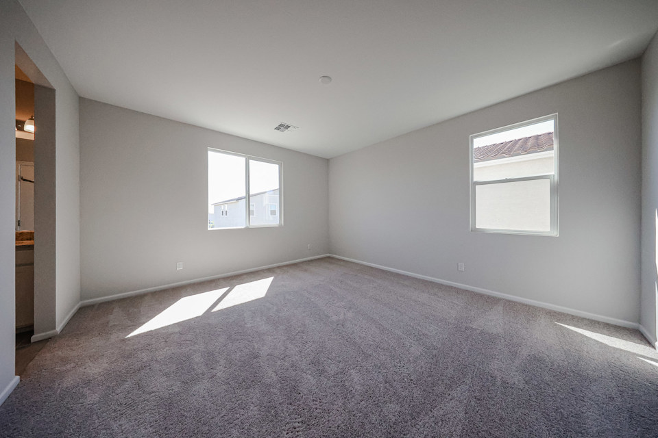 A room with a carpet and windows.
