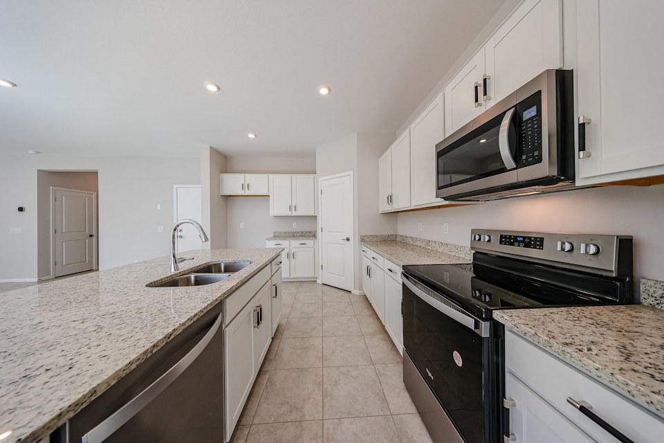 A kitchen with white cabinets.