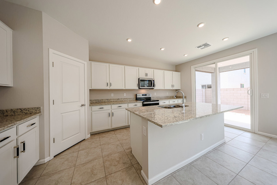 A kitchen with white cabinets.