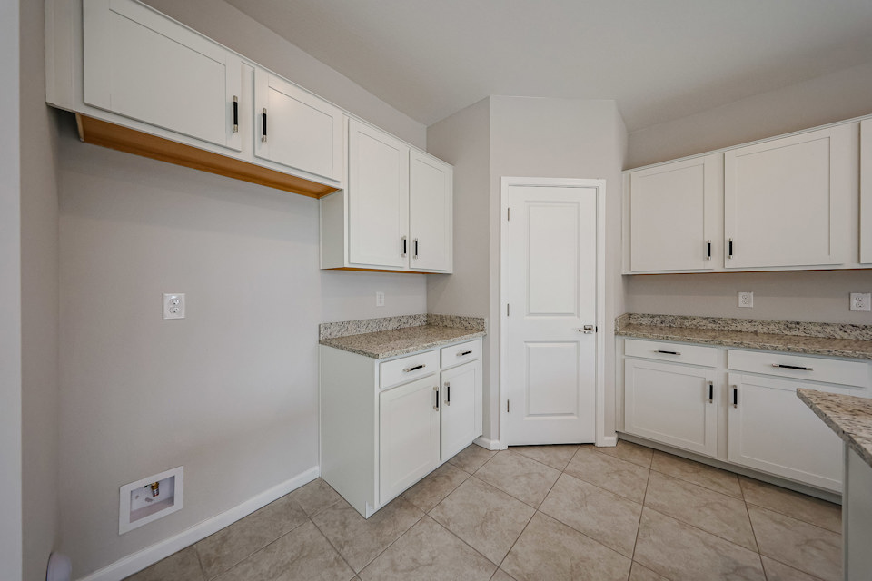 A kitchen with white cabinets.