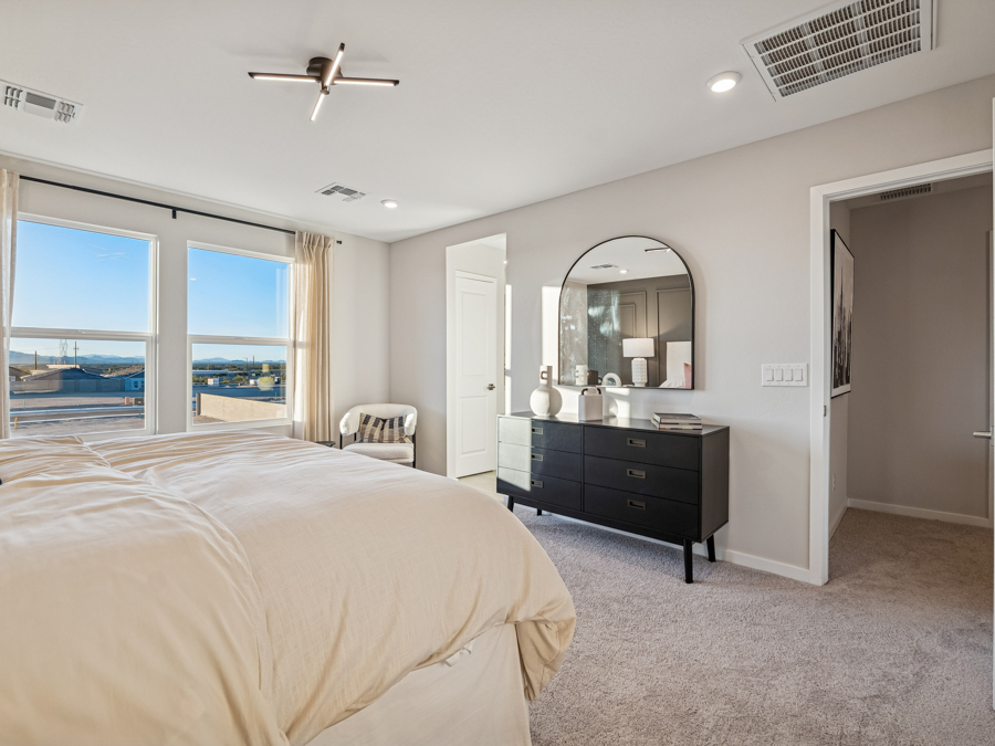 A bedroom with a large mirror.