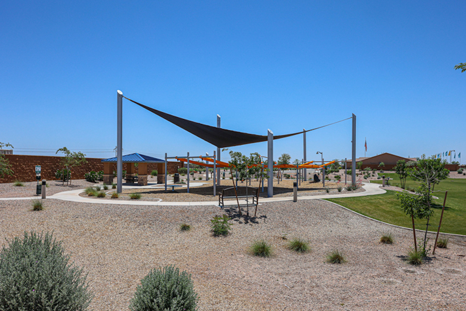 A structure outside with trees and plants around it.