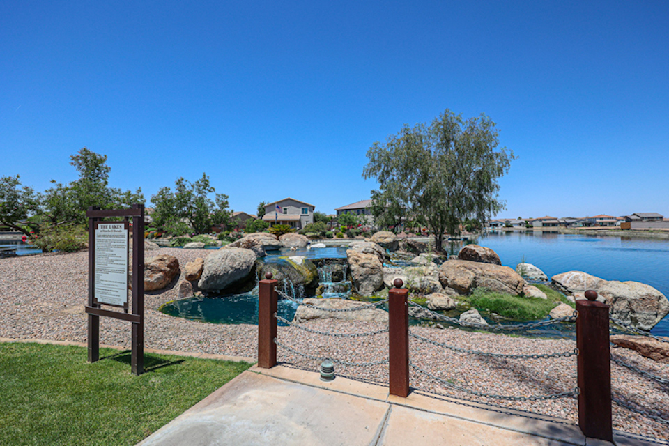 A sign in front of a body of water.