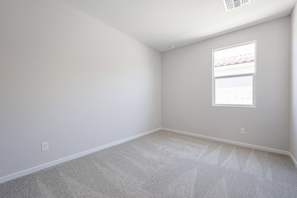 A room with a window and a carpet.