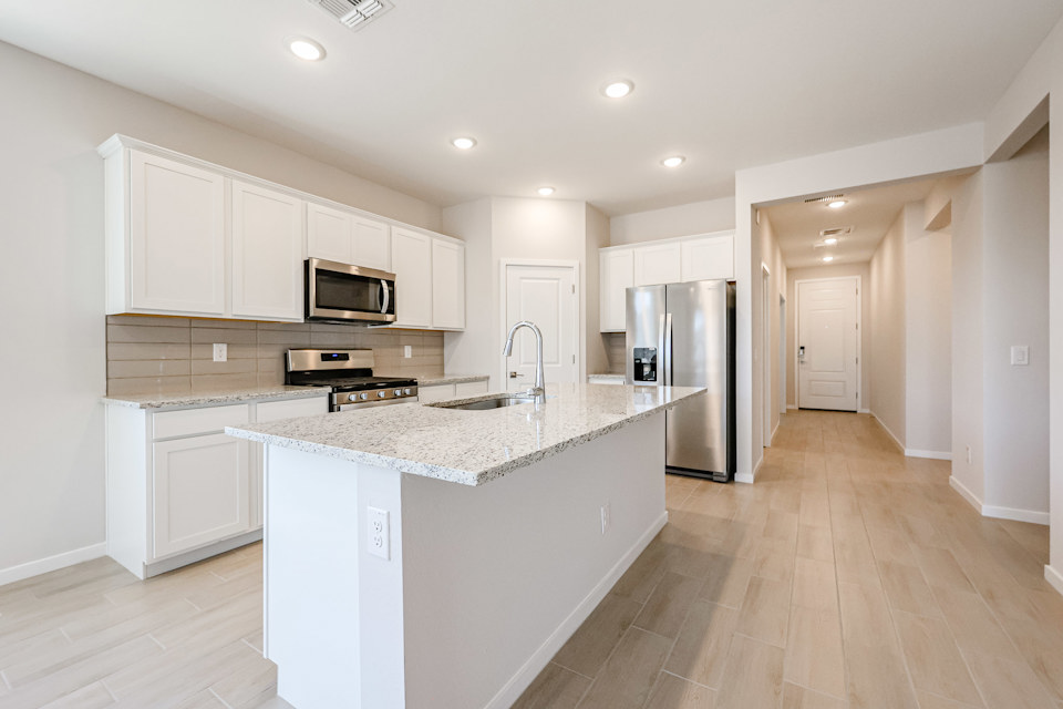 A kitchen with white cabinets.