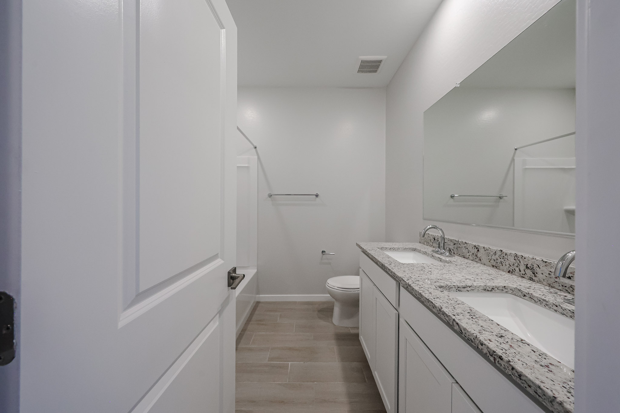 A bathroom with a sink toilet and mirror.