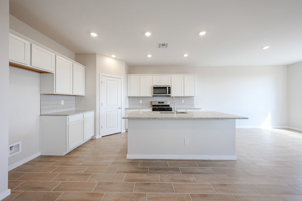 A kitchen with white cabinets.