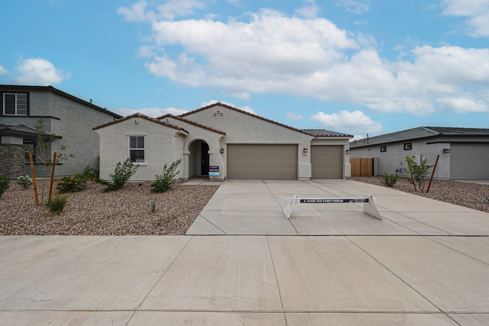 A house with garages and a brick driveway.