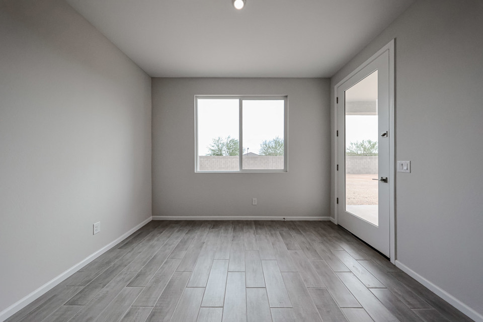 A room with a wood floor and a window with a wood floor.