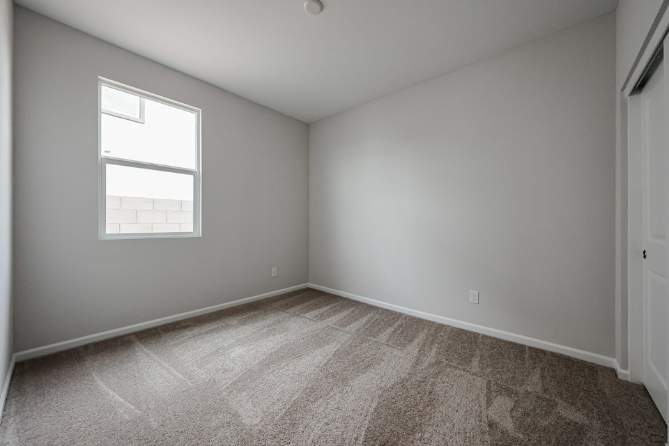 A room with a carpet and a window.