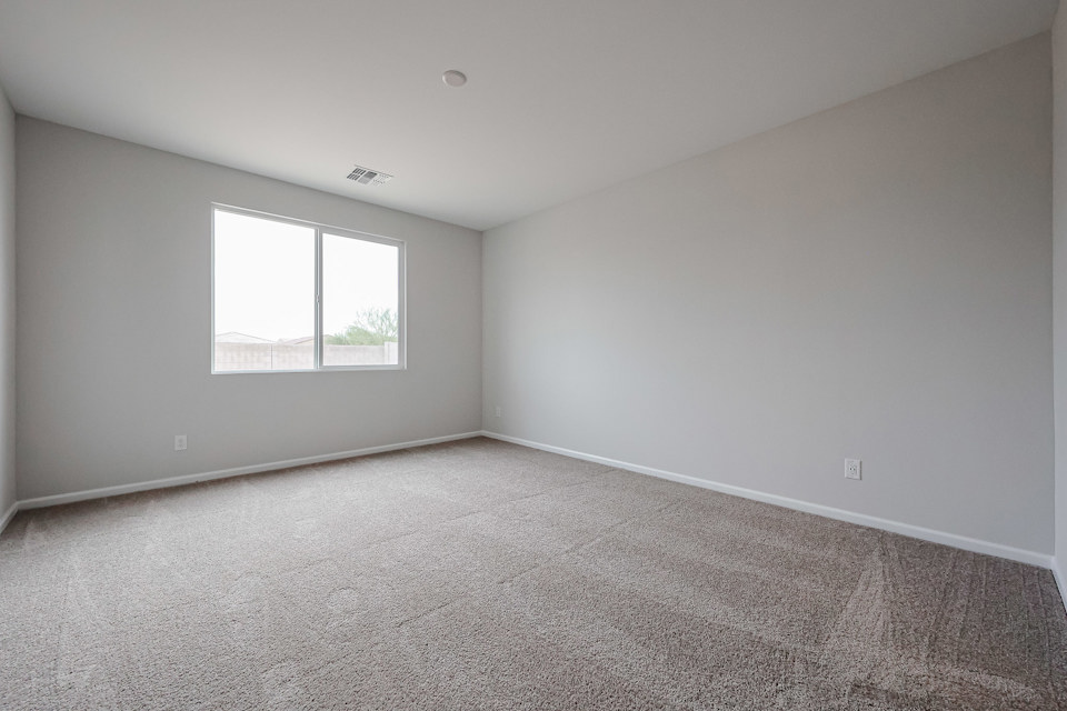 A room with a window and carpet.