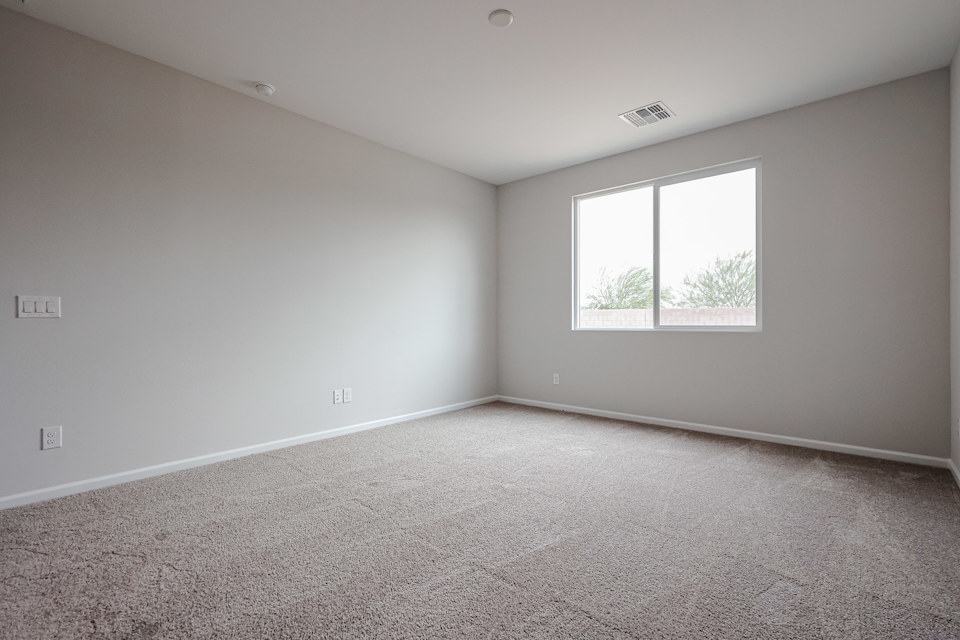 A room with a window and carpet.