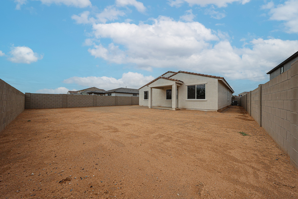 A dirt road with buildings on the side.