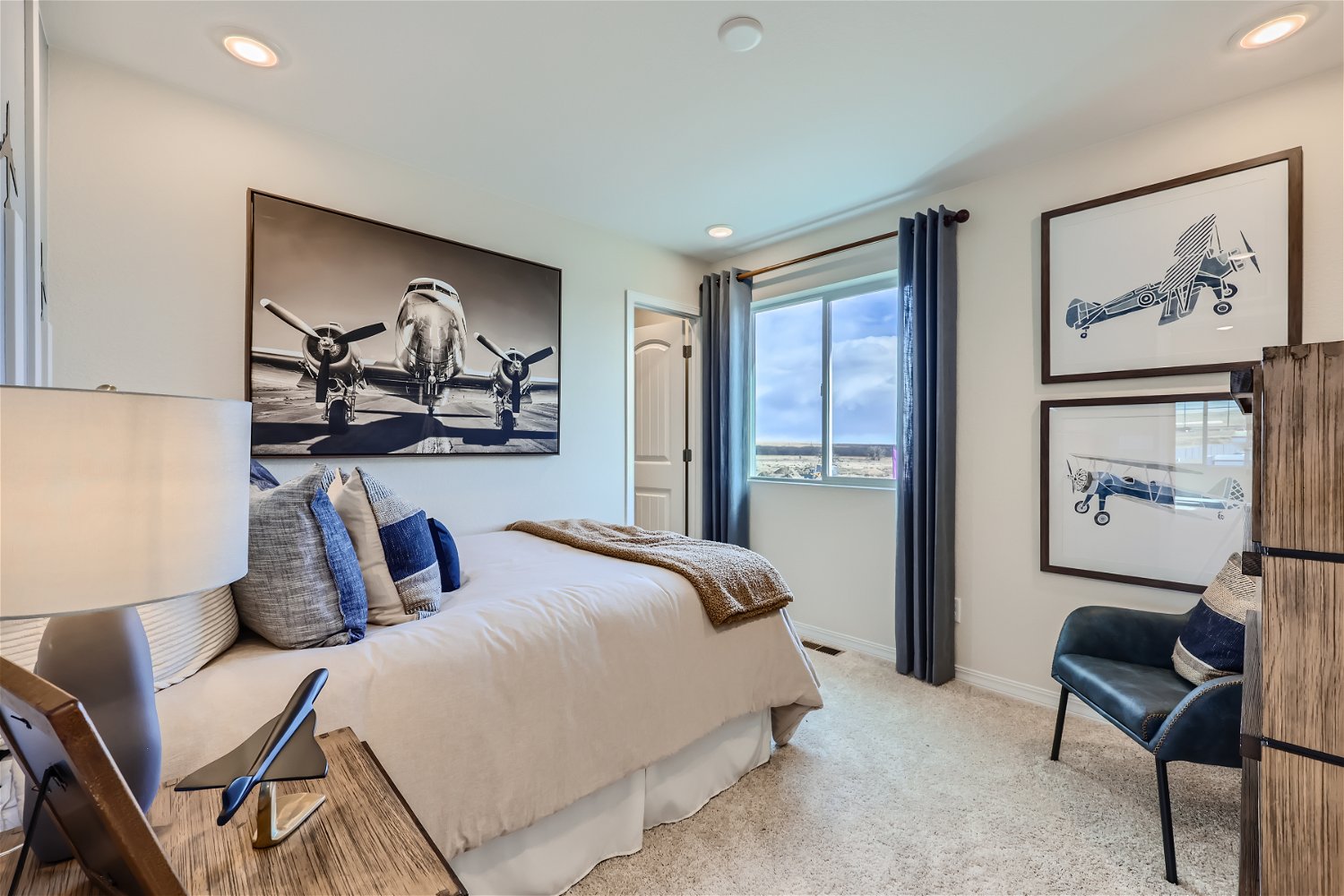 A bedroom with a bed and a chair.