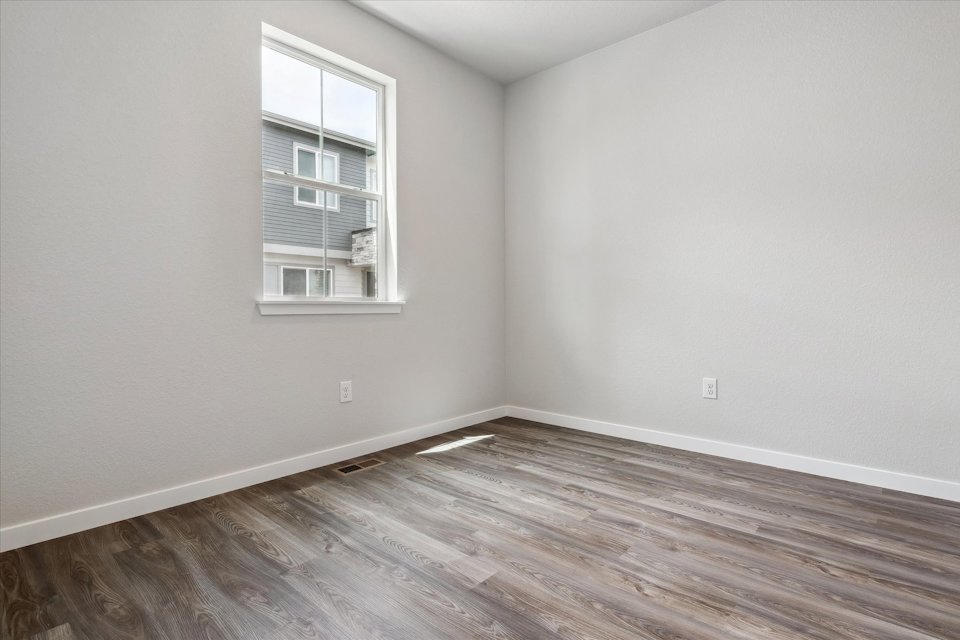 A room with a wood floor and a window.