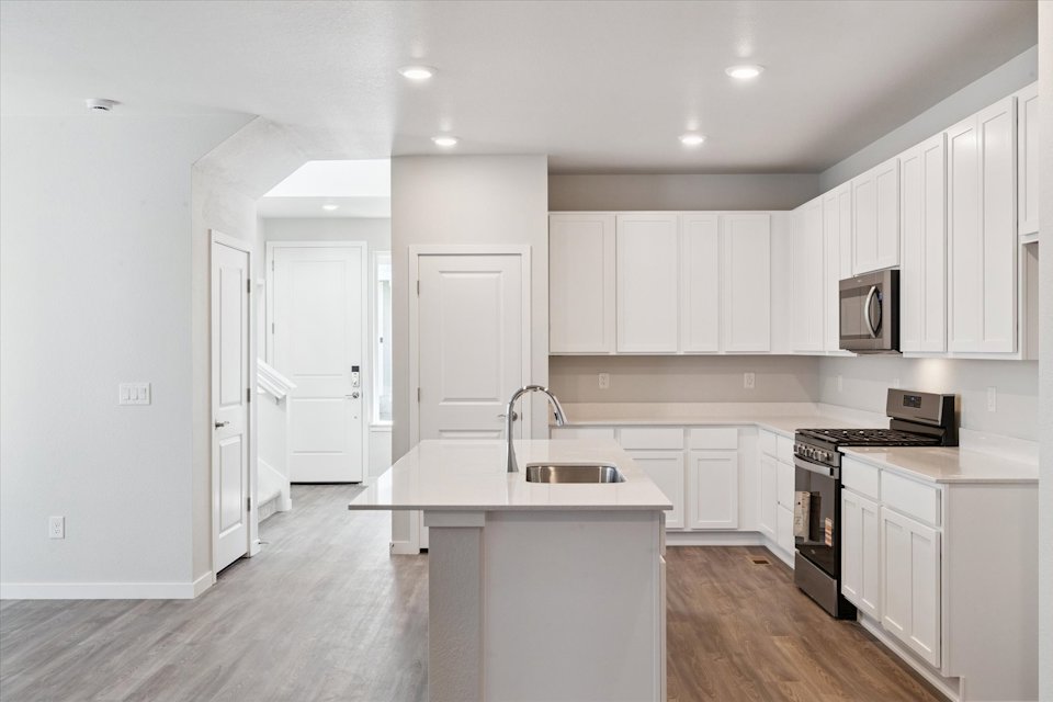A kitchen with white cabinets.