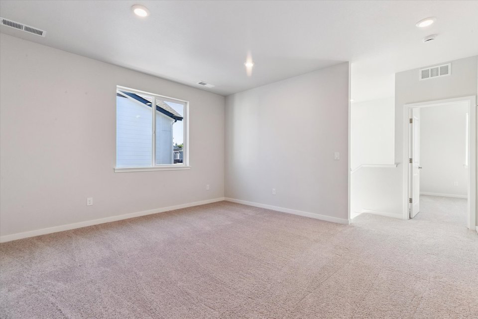 A room with a carpet and a window.