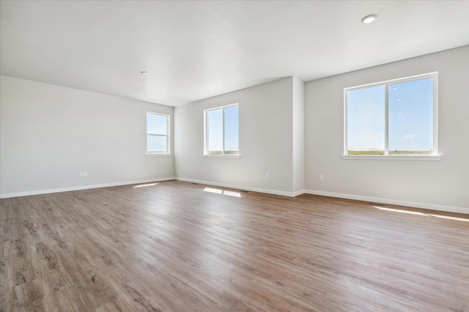 A room with a wood floor and windows.